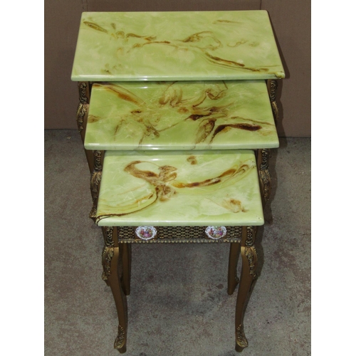 2266 - A nest of three graduated simulated onyx top occasional tables, with gilt finish, applied Limoges st... 