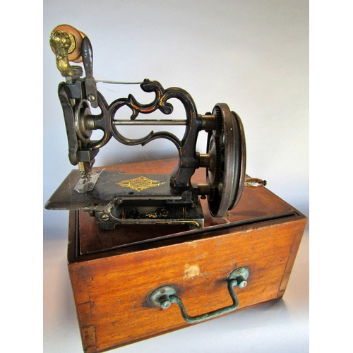 1505 - A small un-marked sewing machine housed in a mahogany carry case.