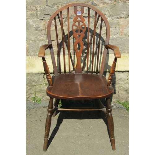 2386 - A Windsor stained elm and beechwood hoop and stick back open elbow chair with pierced wheel splats a... 