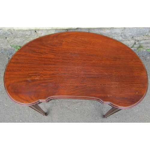 2394 - A low Edwardian mahogany kidney shaped side/occasional table with carved frieze raised on square tap... 