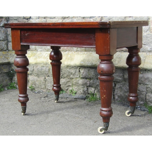 2398 - A Victorian mahogany rectangular fold over top table raised on turned supports with brass caps and c... 