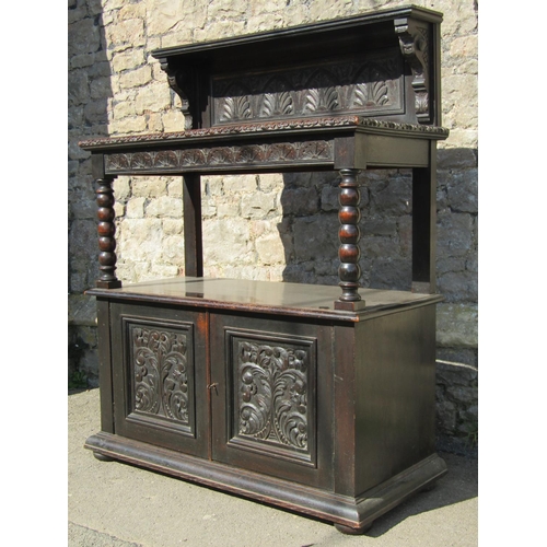 2399 - A Victorian gothic oak two tier buffet with carved foliate detail, partially enclosed by a pair of p... 