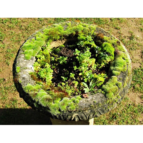 2016 - A weathered cast composition stone garden urn, the squat circular lobed bowl with flared repeating p... 