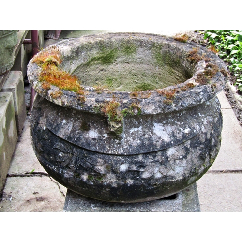 2027 - A weathered cast composition stone cauldron shaped garden urn with flared rim and repeating foliate ... 