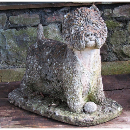 2031 - A weathered cast composition stone garden ornament in the form of a standing terrier with a ball, ra... 