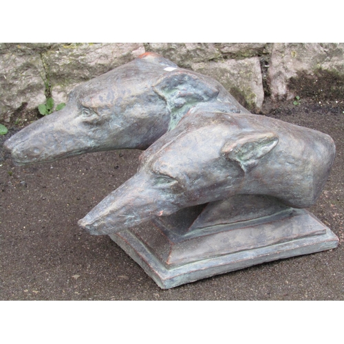 2063 - A cast composition stone study of two greyhound heads, set on a platform base, with simulated bronze... 