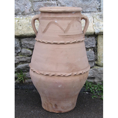 2066 - A clay jar with moulded loop handles, pressed and incised banded detail, 57cm high