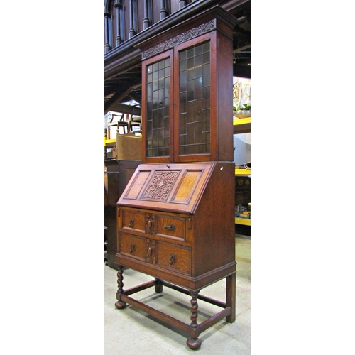 2195 - 1920s Jacobean revival oak bureau bookcase with blind fretwork and split moulded detail, raised on s... 