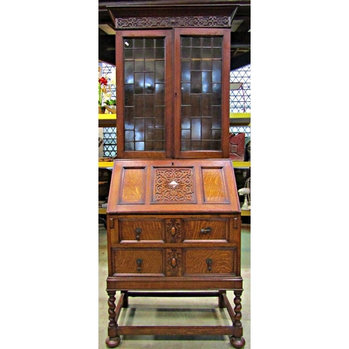 2195 - 1920s Jacobean revival oak bureau bookcase with blind fretwork and split moulded detail, raised on s... 