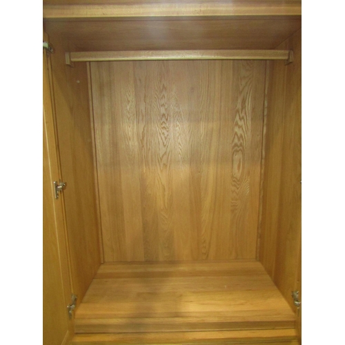 2223 - Contemporary light oak two sectional wardrobe, the upper section enclosed by a pair of rectangular p... 