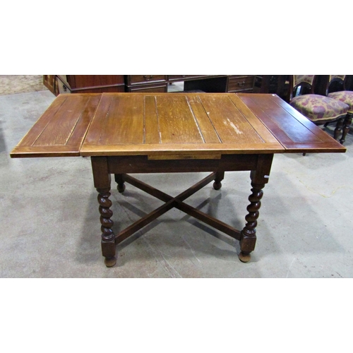 2234 - A 1920s oak drawleaf dining table raised on barley twist supports united by a moulded X framed stret... 