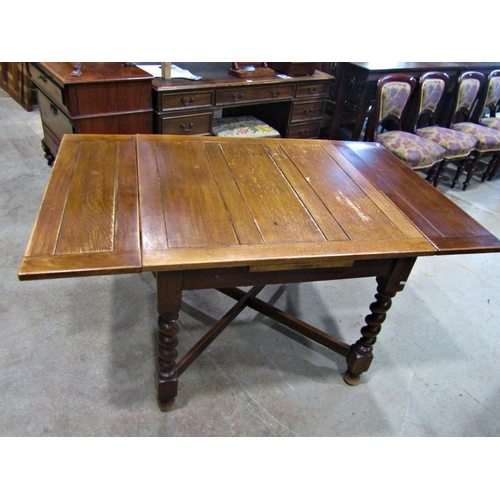 2234 - A 1920s oak drawleaf dining table raised on barley twist supports united by a moulded X framed stret... 