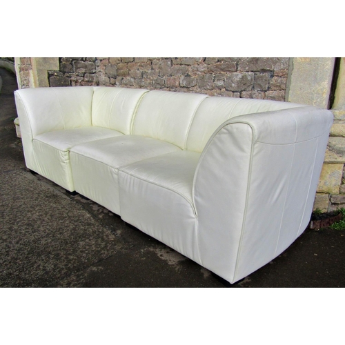 2312 - A contemporary stitched cream leather upholstered three sectional sofa and matching rectangular stoo... 