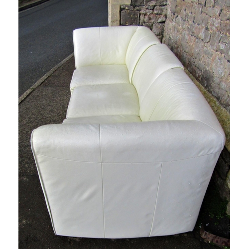 2312 - A contemporary stitched cream leather upholstered three sectional sofa and matching rectangular stoo... 