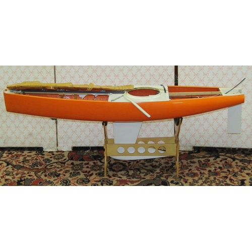 369 - Fibre glass motorised pond yacht on stand with orange hull, length 92cm together with a smaller moto... 