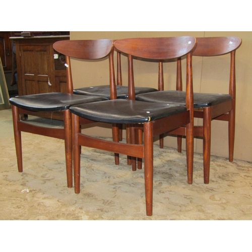 2315 - A set of four retro teak low curved bar back dining chairs with black vinyl upholstered pad seats