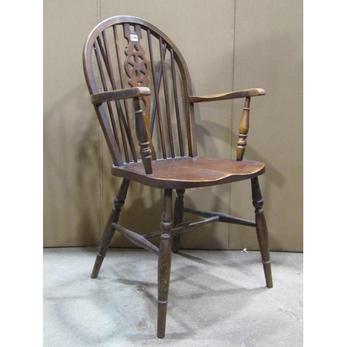 2386 - A Windsor stained elm and beechwood hoop and stick back open elbow chair with pierced wheel splats a... 