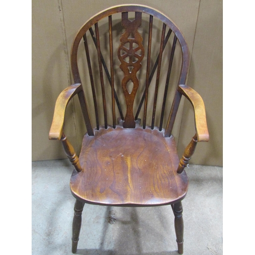 2386 - A Windsor stained elm and beechwood hoop and stick back open elbow chair with pierced wheel splats a... 