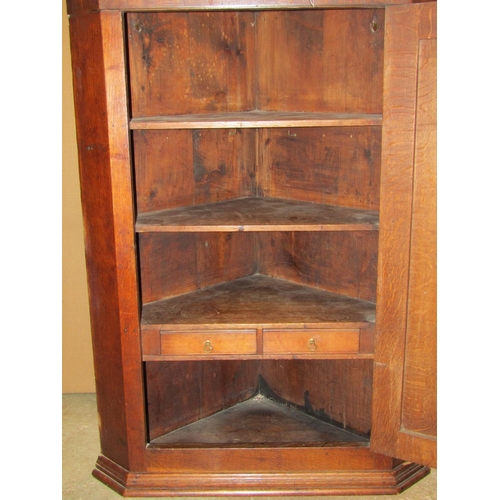 2391 - A Georgian oak hanging corner cupboard enclosed by a rectangular moulded and crossbanded rectangular... 