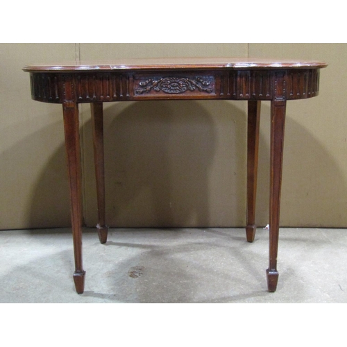 2394 - A low Edwardian mahogany kidney shaped side/occasional table with carved frieze raised on square tap... 