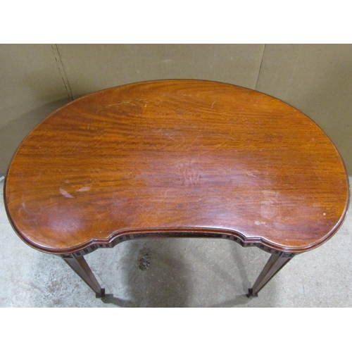 2394 - A low Edwardian mahogany kidney shaped side/occasional table with carved frieze raised on square tap... 