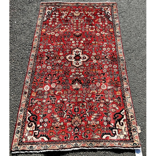 1612 - North West Persian Sarouk rug, with an all over stylised floral pattern on a madder red ground,188cm... 