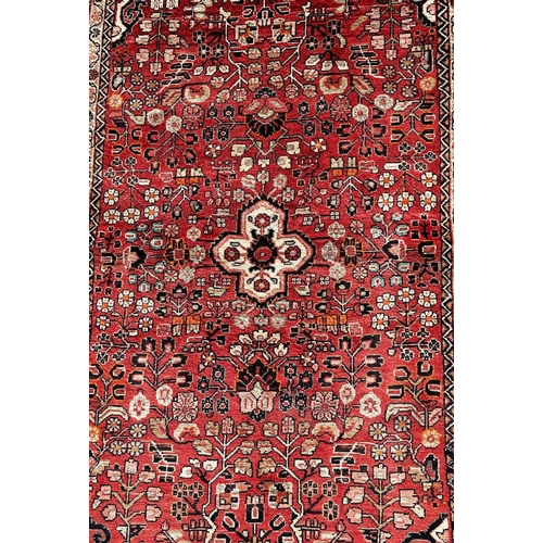 1612 - North West Persian Sarouk rug, with an all over stylised floral pattern on a madder red ground,188cm... 