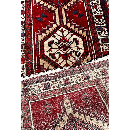 1614 - A Persian runner with a central row interlocking medallions on a red ground, 346cm x 88cm approx.