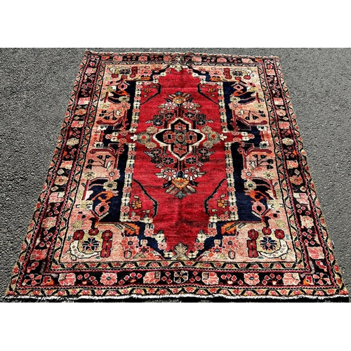 1632 - North West Persian Lillian good condition rug, with a stylised floral medallion on a red ground and ... 