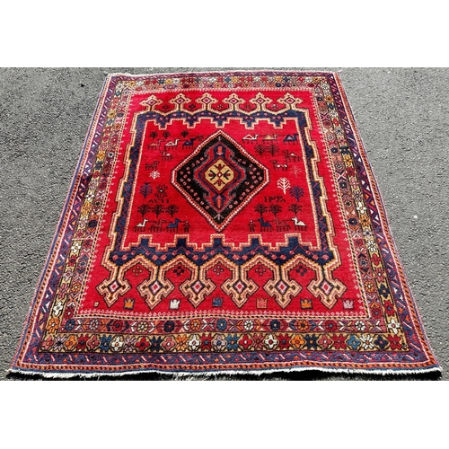 1634 - A Middle Eastern Gabbeh style carpet with a central medallion on a red ground interspersed with styl... 