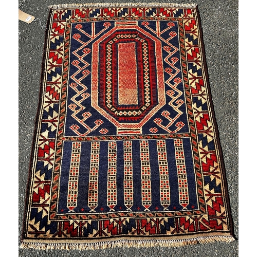 1639 - An Old Baluchi rug with a rhombic stepped medallion  flanked by stylised flowers,134cm x 90cm approx