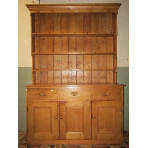 2091 - A stripped and waxed pine farmhouse kitchen dresser, the base enclosed by three rectangular moulded ... 