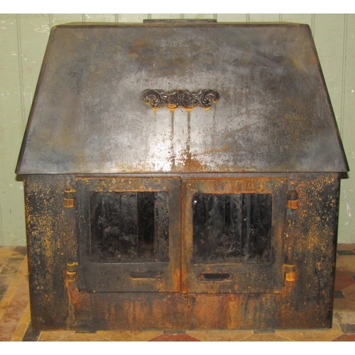 2094 - A large wood burner enclosed by a pair of glazed panelled doors beneath a tapered canopy (manufactur... 