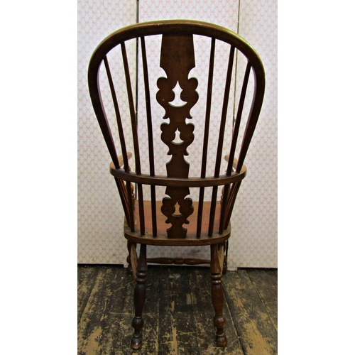 2574 - A Georgian comb back elbow chair in mixed timbers principally ash, with an elm seat on turned suppor... 