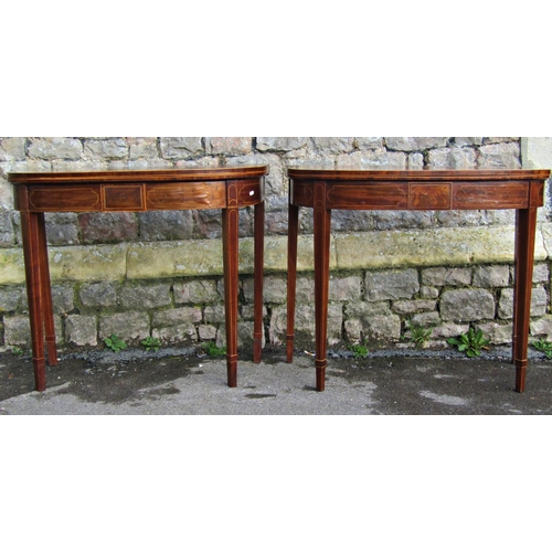 2585 - A pair of Georgian mahogany foldover top card tables, raised on square tapered legs with string band... 