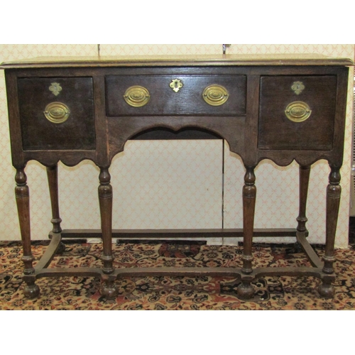 2603 - An antique oak side table, fitted with three drawers, raised on an open framework with turned column... 