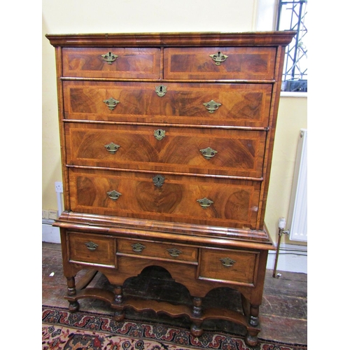 2631 - A Georgian walnut chest on stand, the chest of three long and two short drawers, the stand incorpora... 