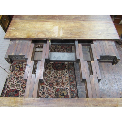 2635 - A Georgian mahogany extending drop leaf dining table, raised on four turned and fluted supports, wit... 