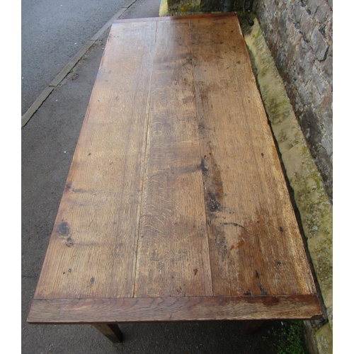 2637 - An old oak farmhouse table, the plank top with cleated ends, raised on four square tapered legs encl... 