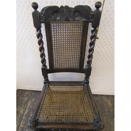 2658 - An antique oak chair in the Carolean style with cane panelled seat and back, with spiral column supp... 