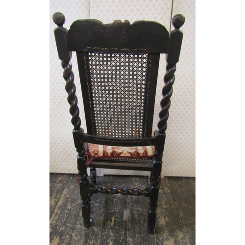 2658 - An antique oak chair in the Carolean style with cane panelled seat and back, with spiral column supp... 