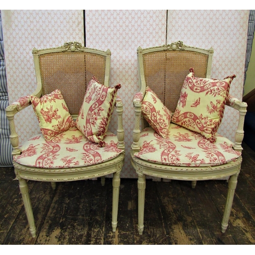 2661 - A pair of open frame salon chairs with carved and painted framework, cane panelled seats and back, a... 