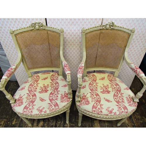 2661 - A pair of open frame salon chairs with carved and painted framework, cane panelled seats and back, a... 