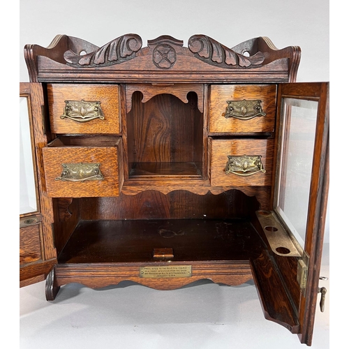 1528 - An Edwardian oak smoker’s cabinet with a fitted interior of drawers and pipe rack, 41cm wide.