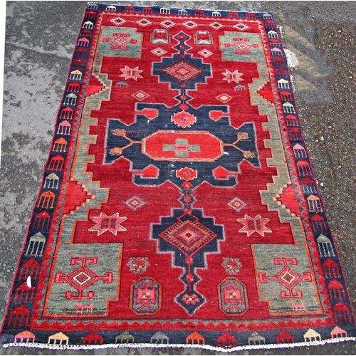 1646 - A slightly worn Kazak carpet with three stepped interlocking lozenges, on a red ground.  188cm x 118... 