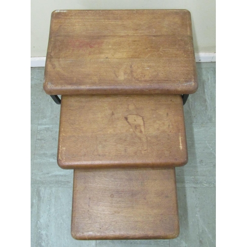 2479 - A nest of three sturdy oak occasional tables with heavy oak tops on shaped iron supports, 50 cm wide... 