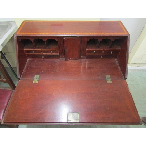 2486 - A Georgian mahogany writing bureau of four long drawers, fall flap with inlaid detail enclosing the ... 