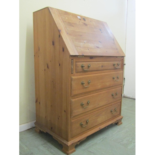 2492 - A pine writing bureau of four long drawers, the fall front enclosing a very simply fitted interior, ... 