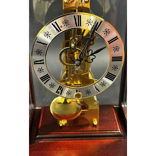 1370 - A contemporary skeleton clock, in an arched mahogany coloured and brass inlaid case