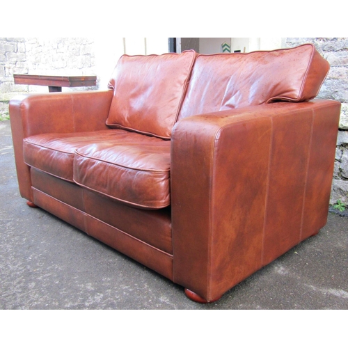 2308 - A contemporary stitched tan leather upholstered two seat club sofa, with loose seat and back cushion... 